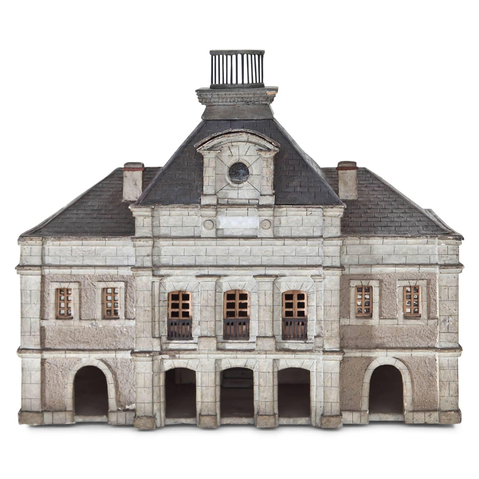 Hand-painted architectural model of a two-level house in the style of the 19th century with corner rustication, a slightly protruding middle Avant-Corps and pilasters. The back shows a cut-out with an open view of the staircase and banister.