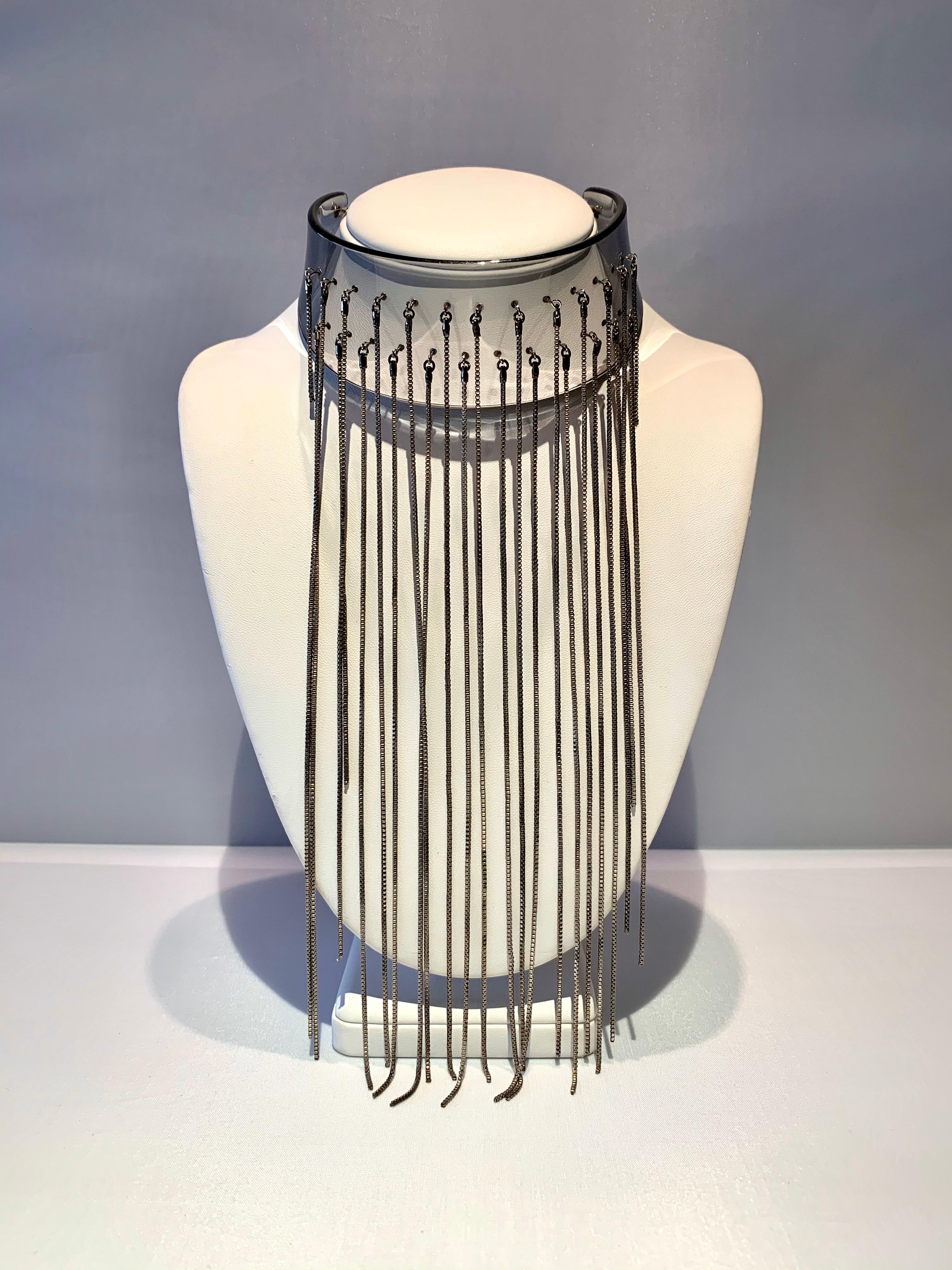 An architectural modern acrylic fringe statement necklace, comprised out of blue acrylic featuring a dramatic waterfall of silver-tone metal chains. The impressive modern high fashion necklace was made in Paris, France circa 1970.


Note: the