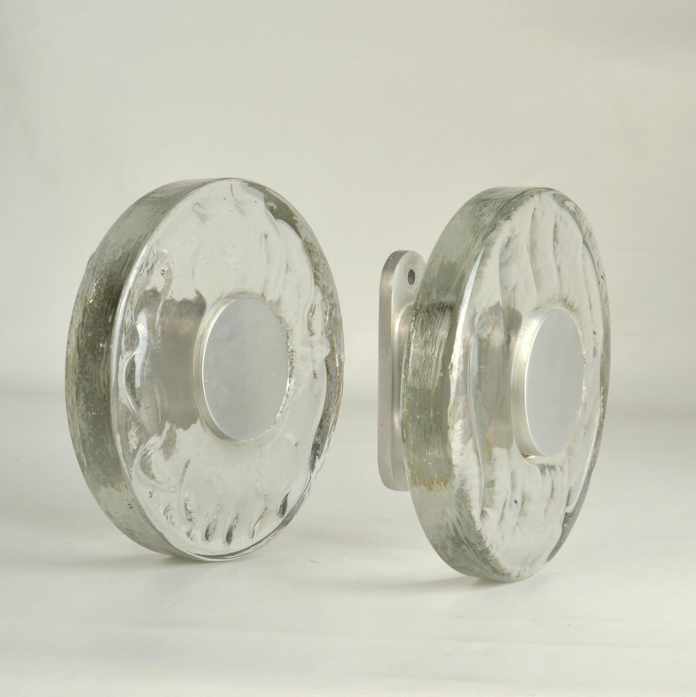 Pairs of round double door 1960's push and pull handles in clear glass with subtile wave relief, cast glass (2cm thick) with aluminum fittings. They are designed for a glass doors but suitable for any kind of doors including wooden doors. The glass
