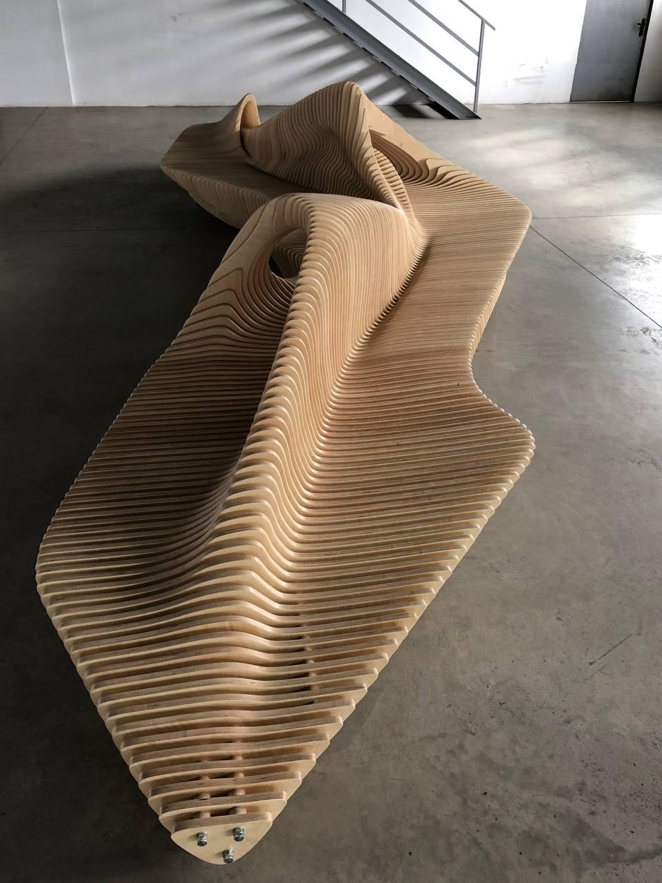A sculptural double-sided bench designed for both functionality and aesthetics. Crafted from 18mm plywood and
reinforced with metal rods, its fluid, dynamic form allows seating from both sides, making it ideal for public spaces,
offices, and