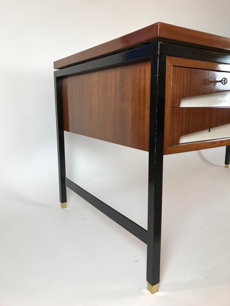 A unique partners desk comprising of white and brown formica on a black metal frame with brass sabots. There are 2 drawers to the front and rear.

 