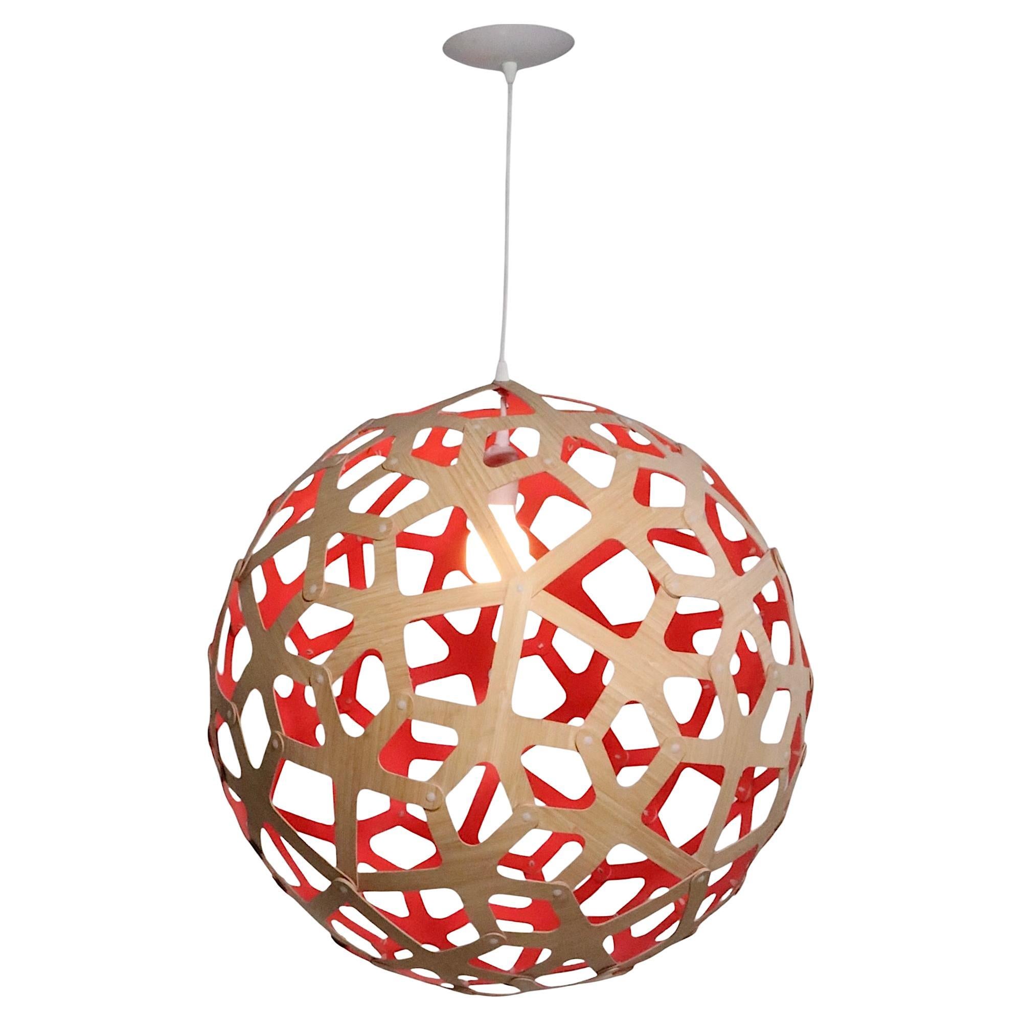 Lustre boule architectural en forme de sphère, conçu par David Turbridge, fabriqué en Nouvelle-Zélande. La grande forme A est constituée de fines pièces de contreplaqué pliées, en finition naturelle à l'extérieur et en peinture couleur corail à
