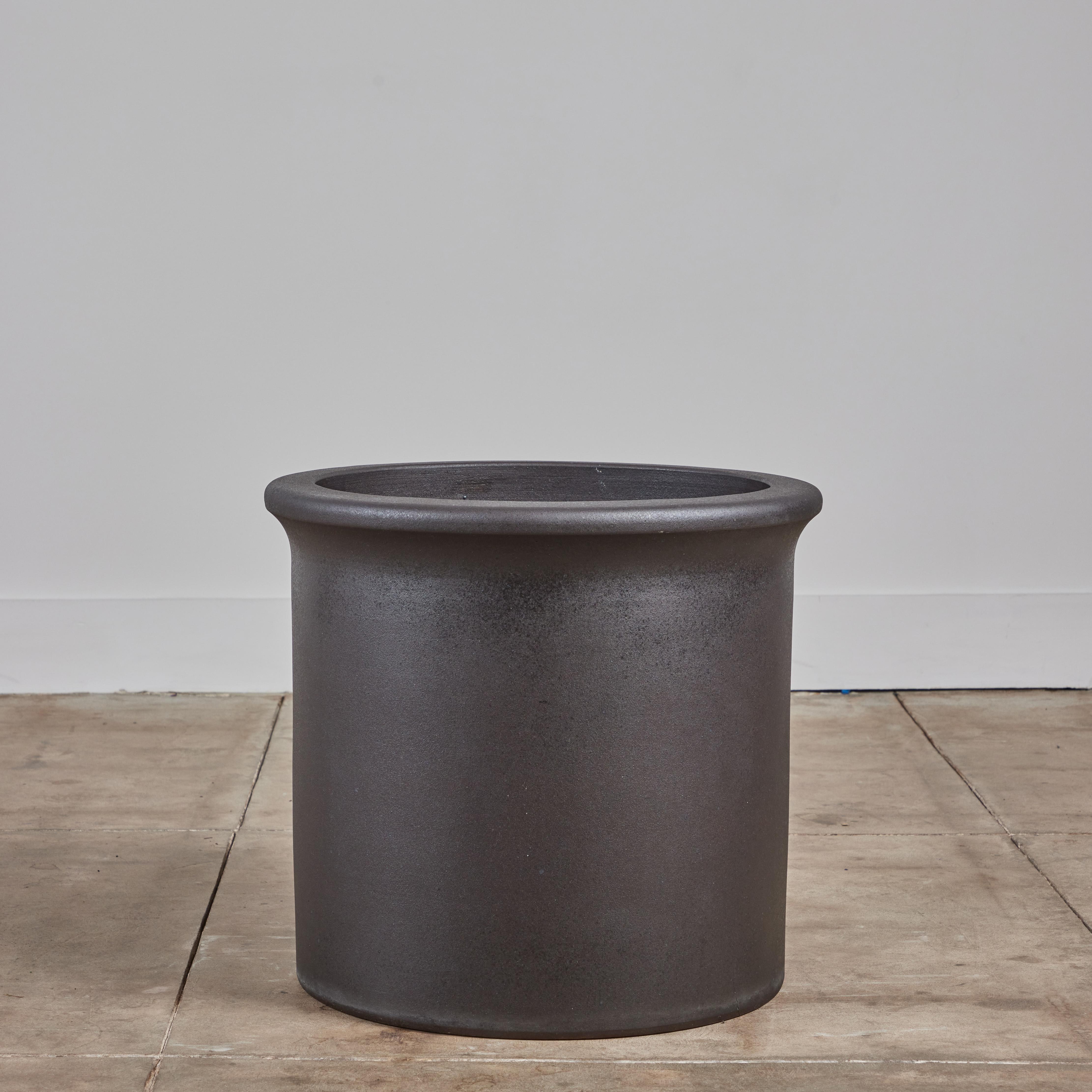 A beautiful black glaze tulip planter by Architectural Pottery. This AP-3206 planter has a drum shape with a rounded lip that curves in at the top of the piece. Architectural Pottery containers can be planted in directly or used as a decorative