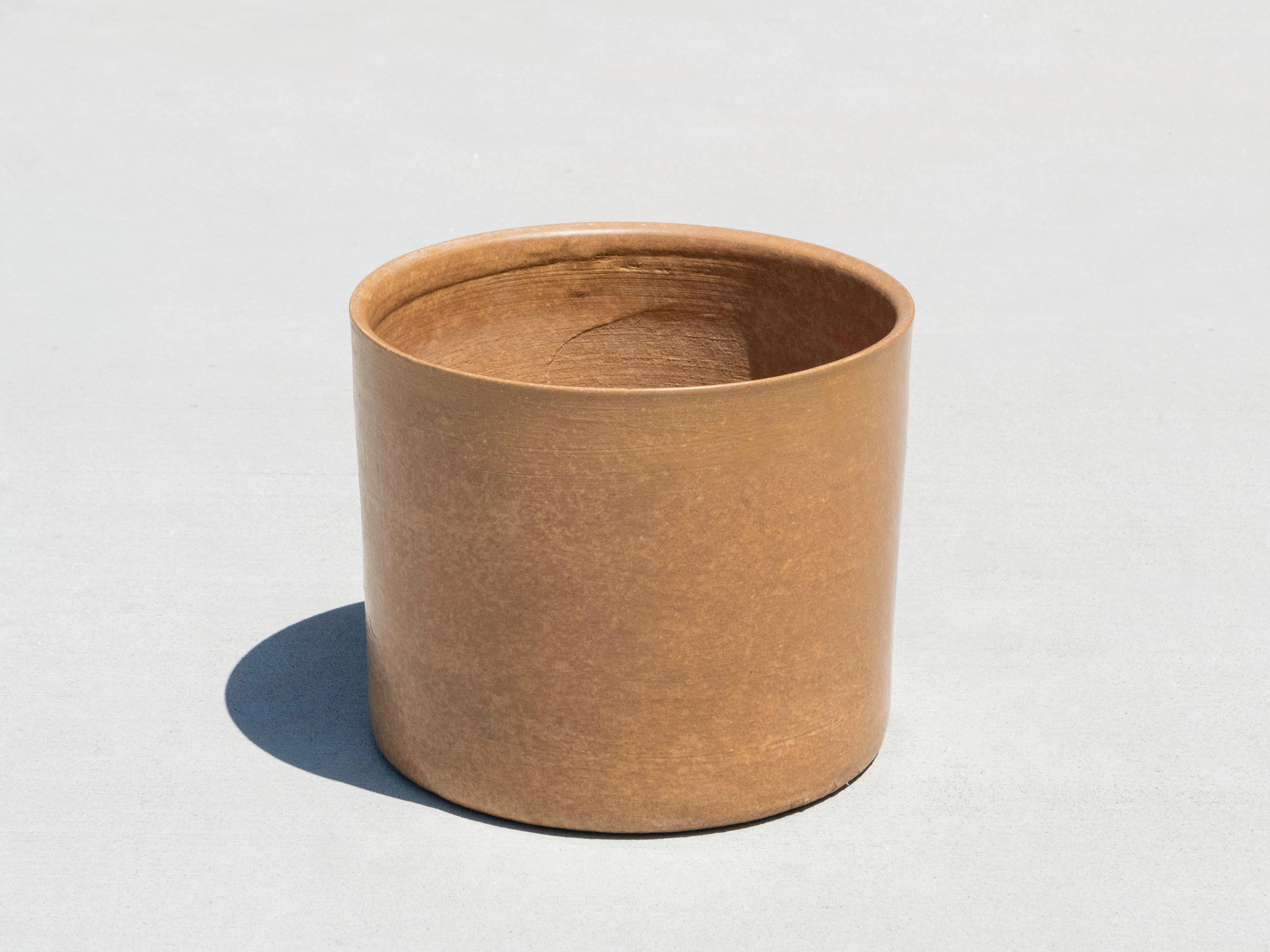 Fioriera cilindrica Architectural Pottery attribuita a Laggard Tackett con smalto ocra. Lo smalto presenta una finitura strutturata dovuta al processo di cottura: probabilmente si tratta di un 