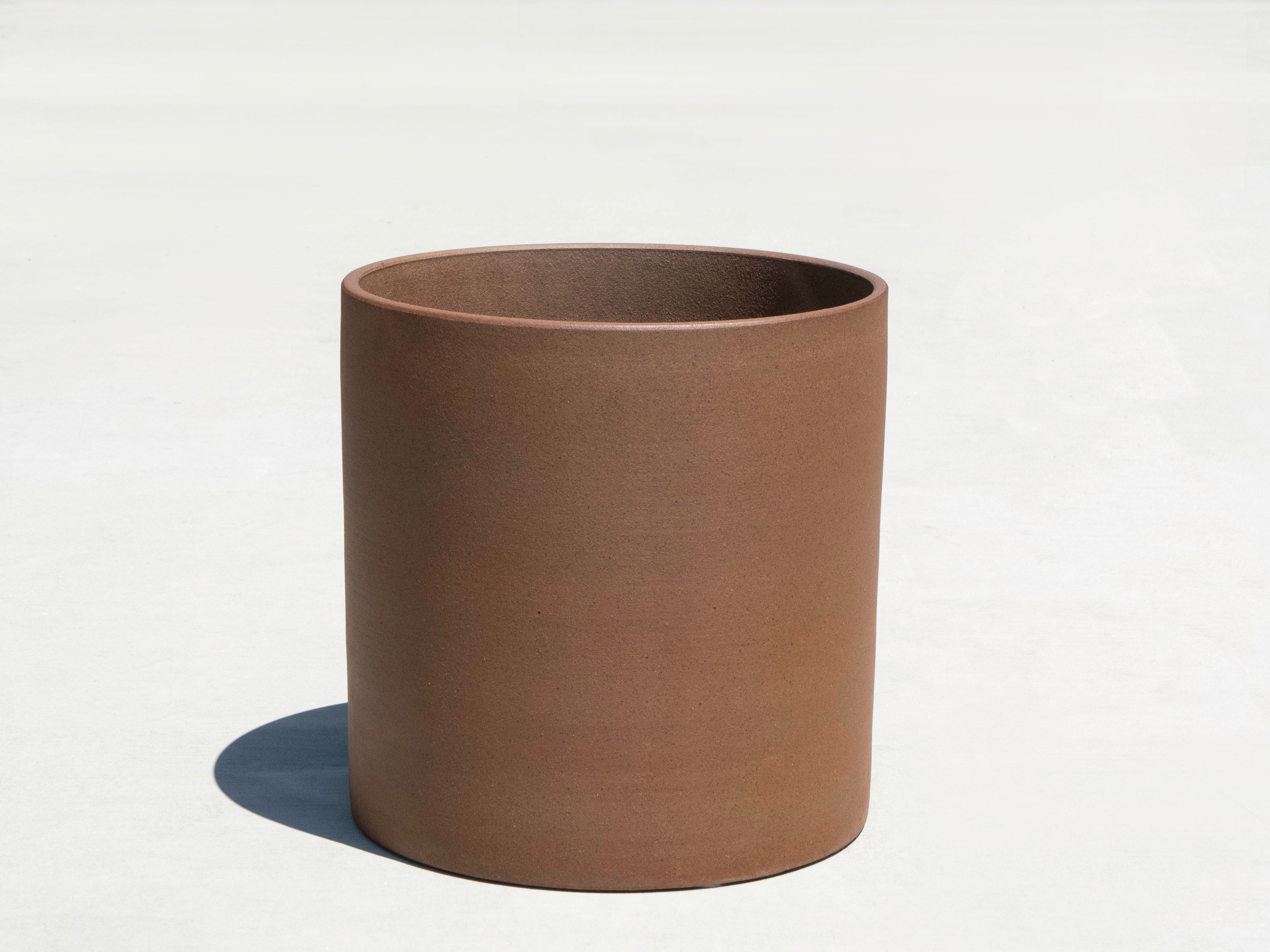 Jardinera cilíndrica Architectural Pottery de gres. La maceta está en muy buen estado y presenta muy poco desgaste. Uno de los lados muestra una variación de color en el material.

Estructuralmente sano, sin desconchones ni grietas. La base es