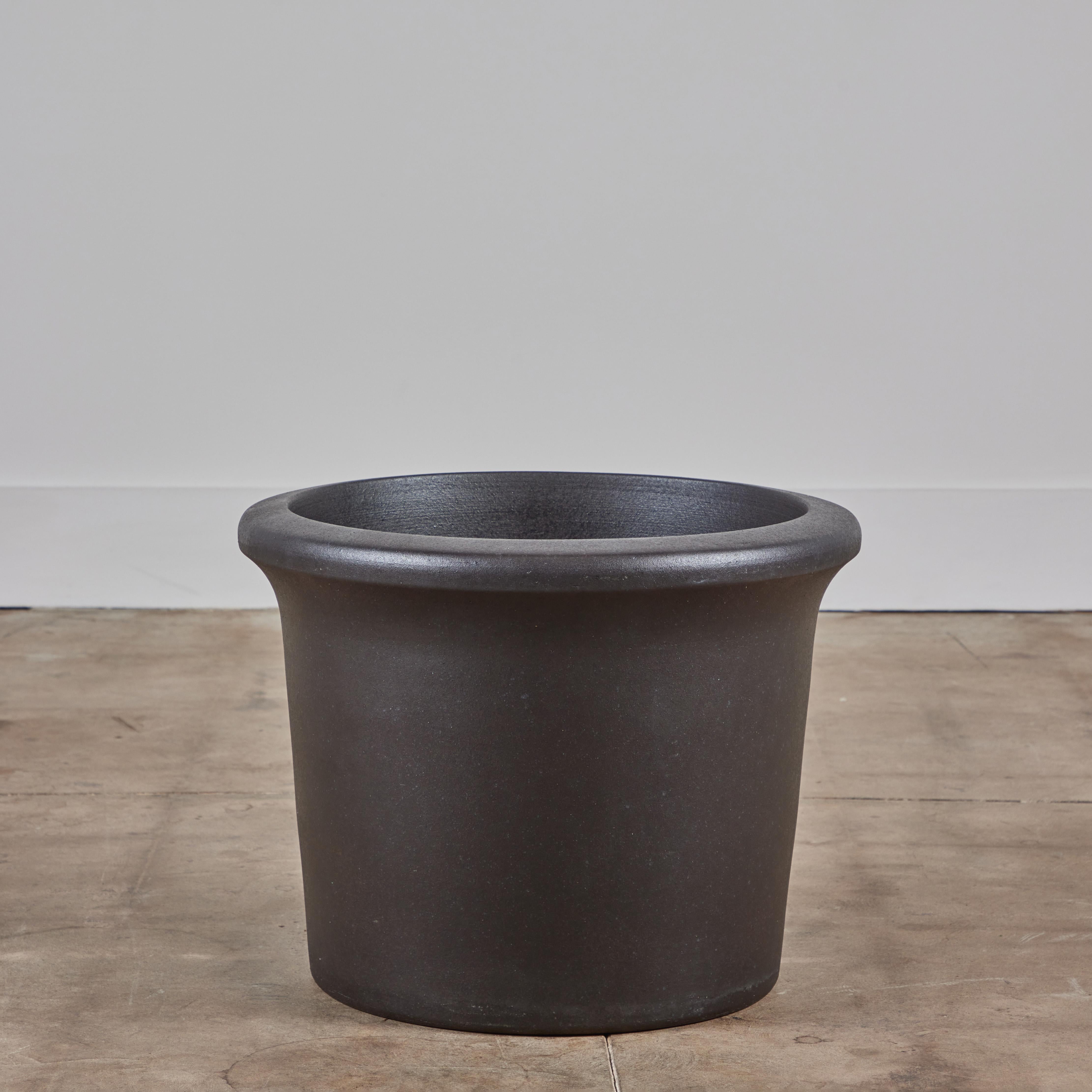 Ein schöner Tulpen-Pflanztopf mit schwarzer Glasur von Architectural Pottery. Dieses AP-3203 Pflanzgefäß hat die Form eines Fasses mit einer abgerundeten Lippe, die sich nach oben hin verjüngt. Architectural Pottery Container können direkt bepflanzt
