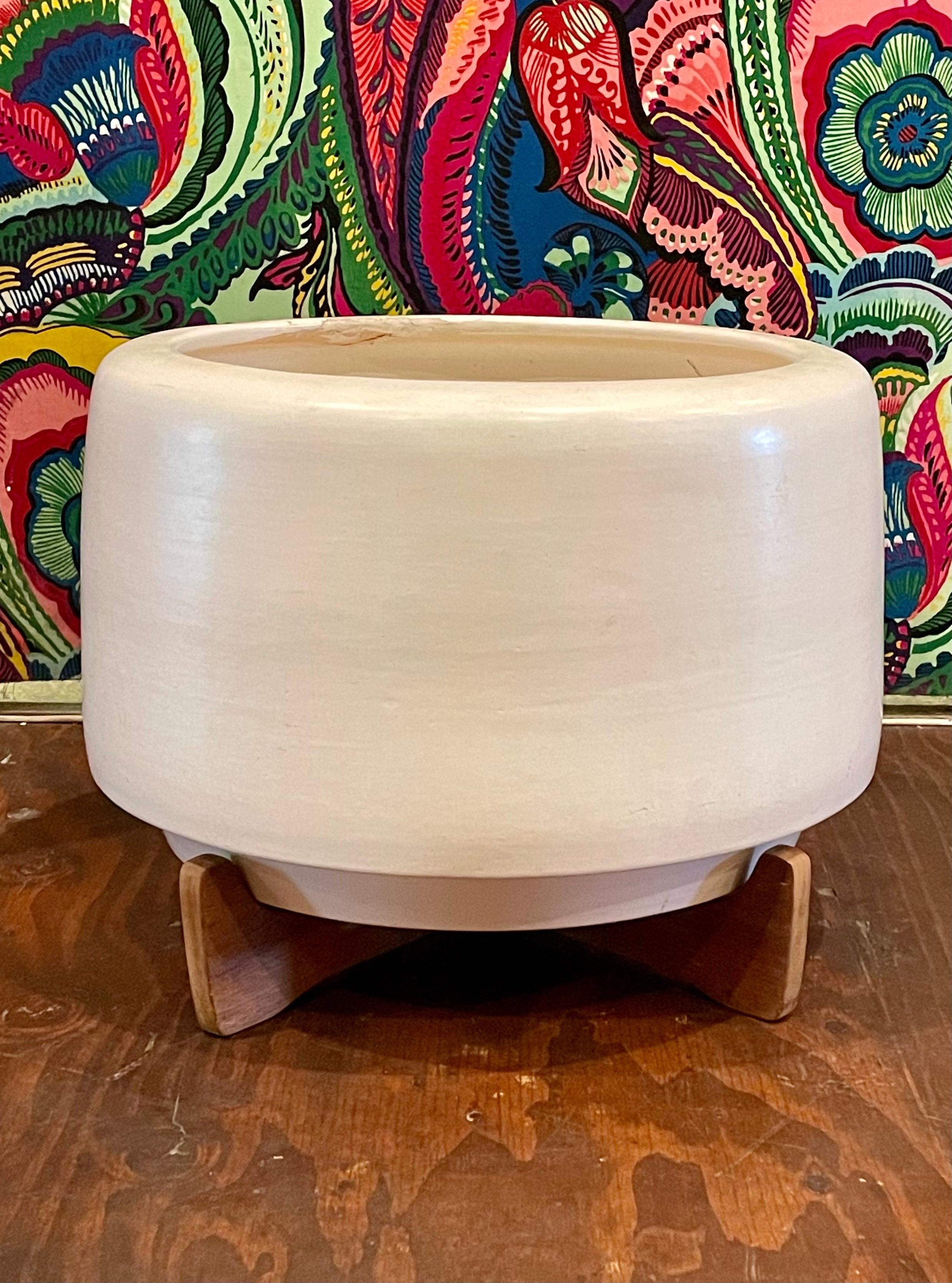 Period Architectural Pottery planter is commonly known as the “Tire”. This design is by Rex Goode and John Follis. Planter is in good shape has a chip on the edge top rim as shown, and retains the California redwood stand. Signed with the AP