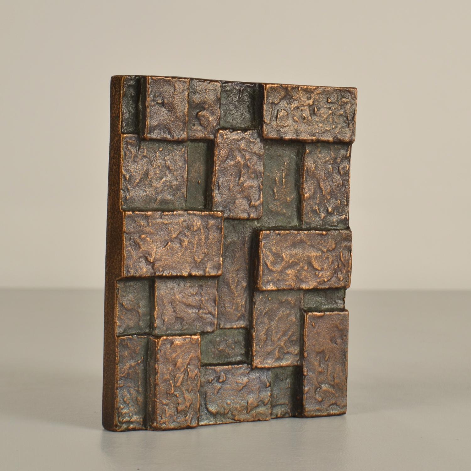 Single door handle with geometric relief that is part  textured. Cast bronze relief in perfect condition. The bronze has a strong patina due to the textured surface and its age, circa 1970's. 
It will create personality to any door. The handle can