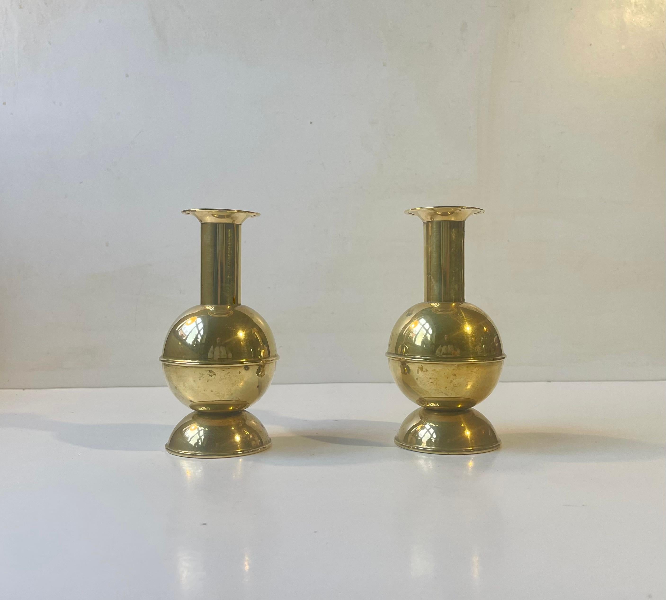 A pair of brass candlesticks designed and manufactured in Scandinavian during the 1970s. Interesting architecturally inspired 'Ball' shaped center pieces. The candlesticks are to be fitted with regular sixed candles. The style of this set is