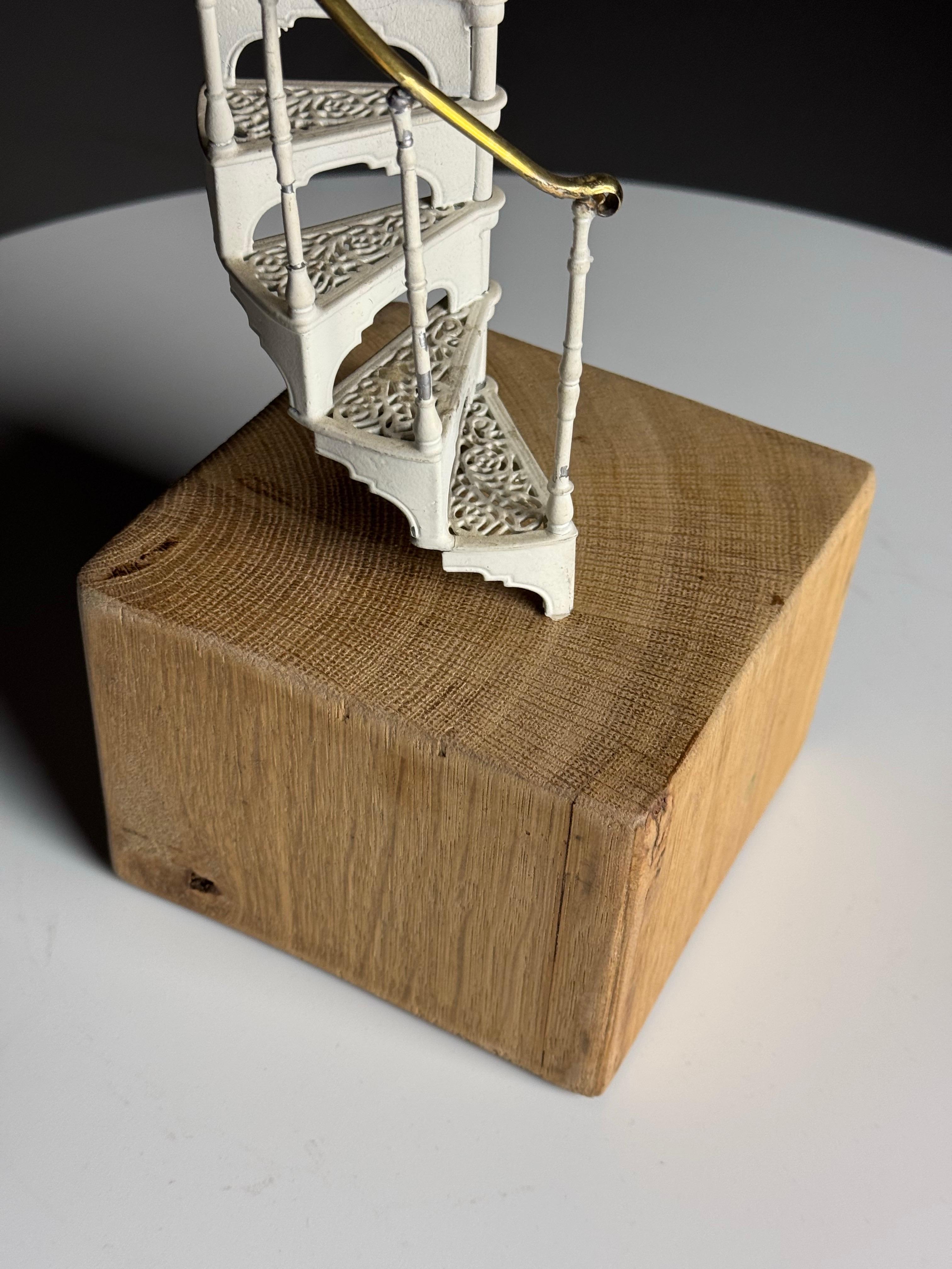 Architectural miniature staircase

Elegant miniature spiral / spiral staircase. Made of metal, painted white. Presumably early/mid 20th century. On later oak base (we can make this black if required).

Dimensions: 49,5h x 13w x 13d