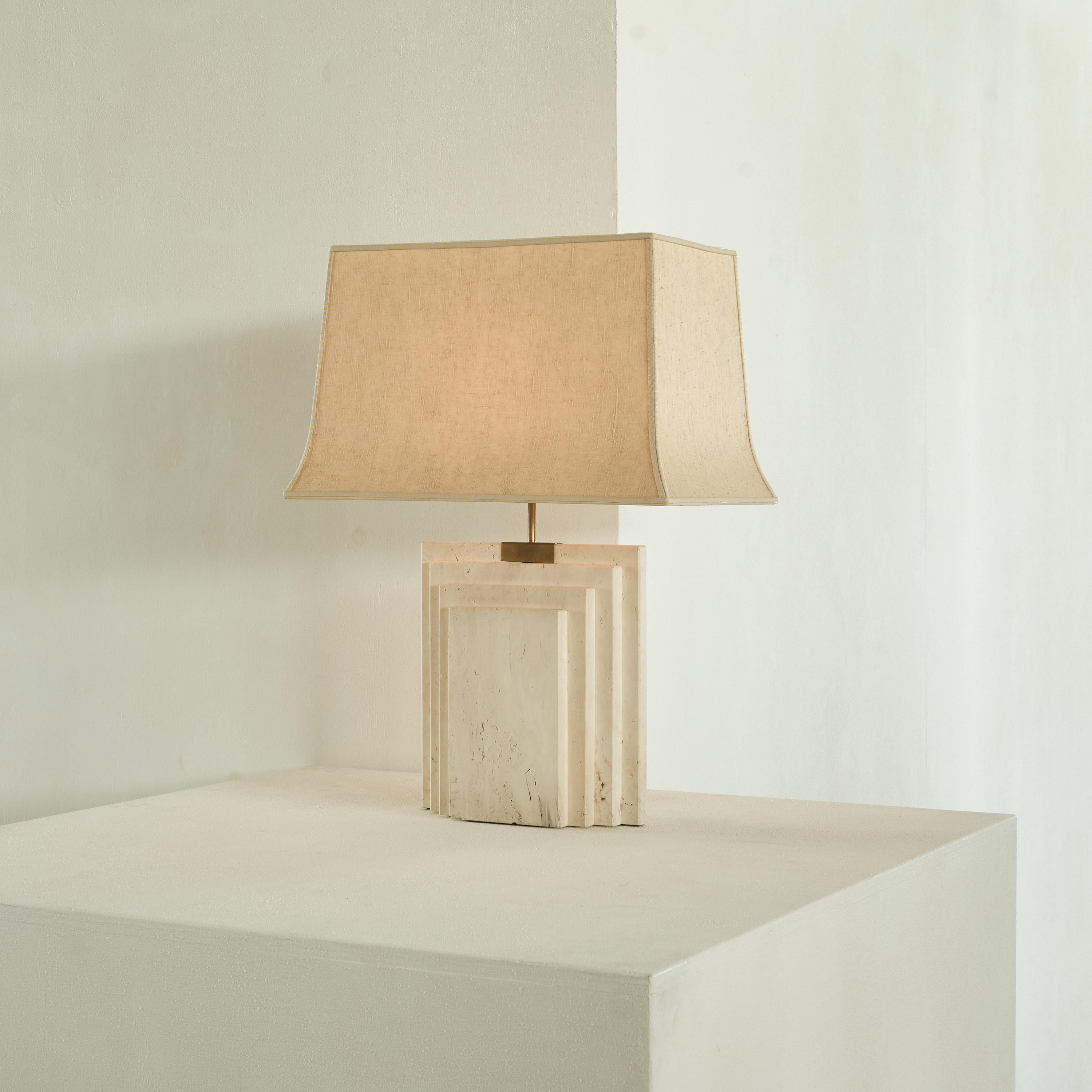 Architectural table lamp in travertine and brass, Belgium, 1970s.

This well sized and very heavy table lamp shows a modern, timeless design. Its stunning base was made in travertine, with a brass element on top holding the light bulb socket. The