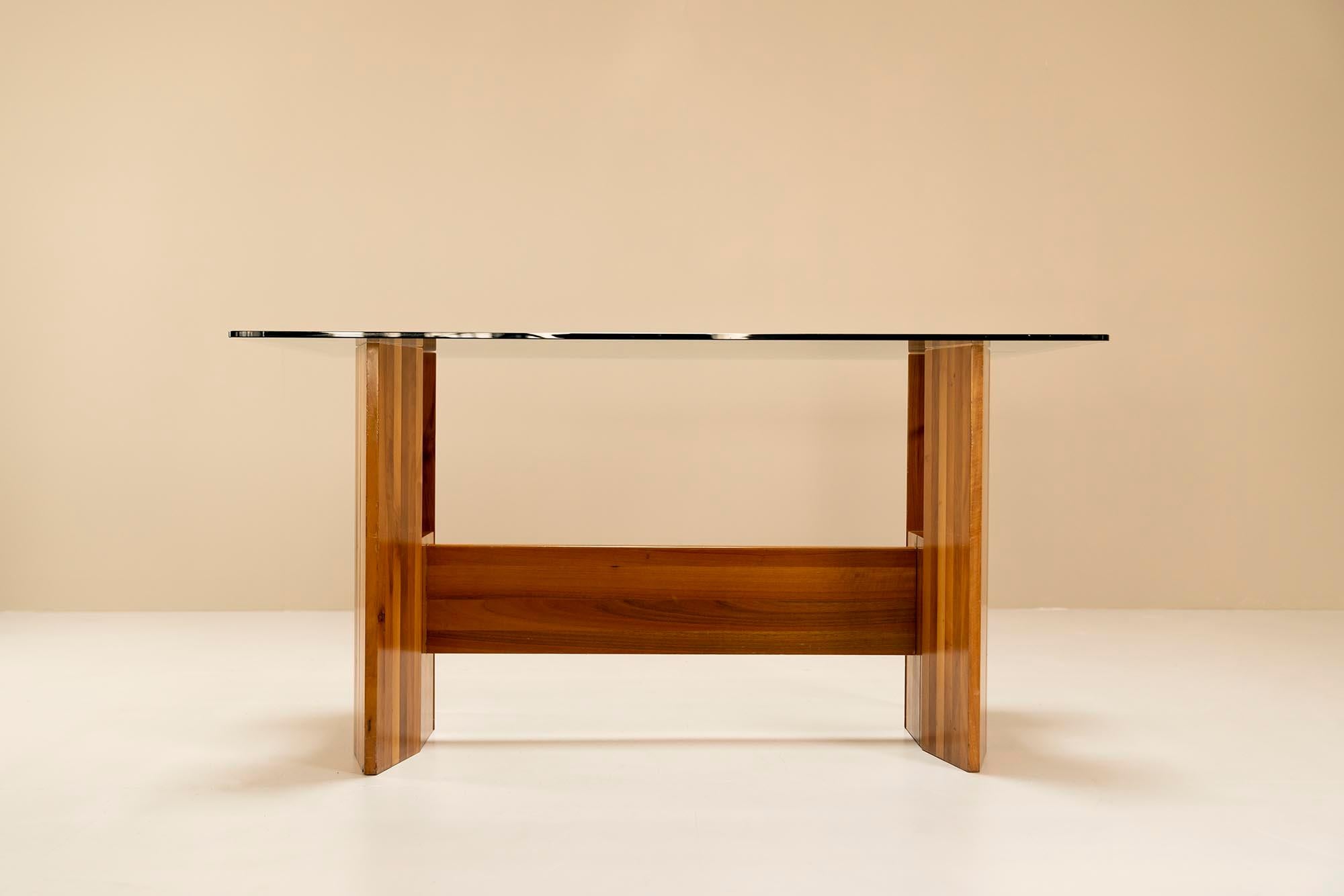 A beautiful Italian (console) table that can also serve as a desk due to its size. The two large hexagonal legs consist of walnut slats that are tightly attached to each other. From the center of the leg there is a see-through. Just below the glass