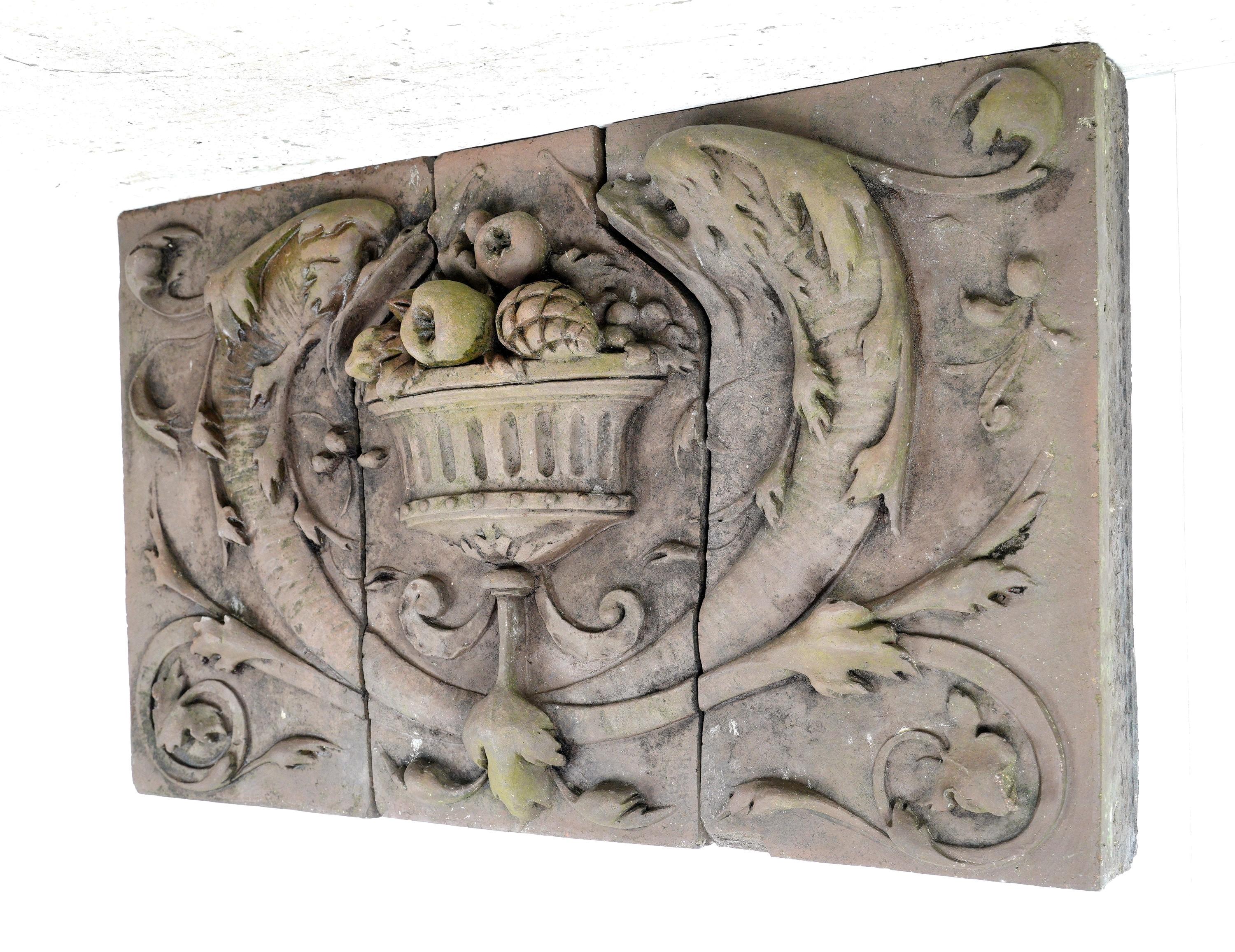 This ornate terra cotta stone frieze features an ornate high relief of swirled floral foliate and fruit details. This is in good condition, with some surface wear on the corners. The frieze is made up of three pieces. Please note, this item is