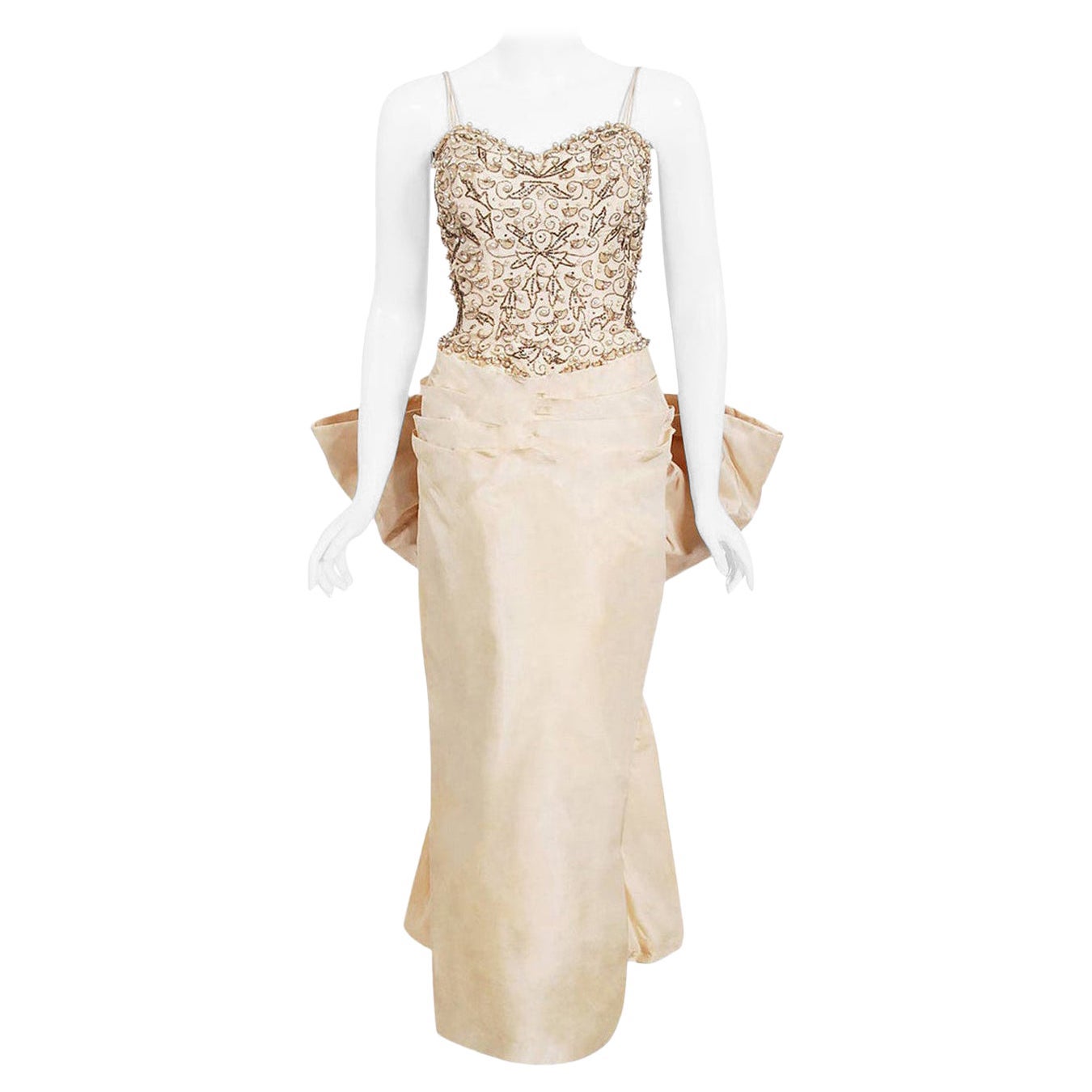 Vestido de seda marfil con pedrería y lazo en la espalda, de los años 50, de alta costura a medida, de archivo en venta