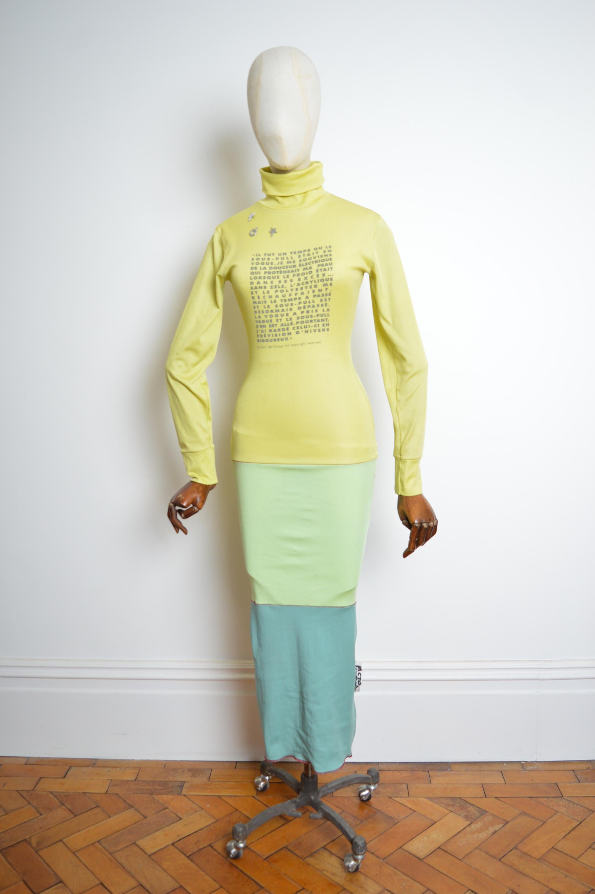 Crafted from various recycled polyester jersey panels featuring printed poetry detailing and body contouring shape. 
High neck / long sleeves / funkin fashion factory. 
Pit to Pit; stretchy 17-23”
Pit to Cuff; 20”
Nape to Hem; 56”
Waist;