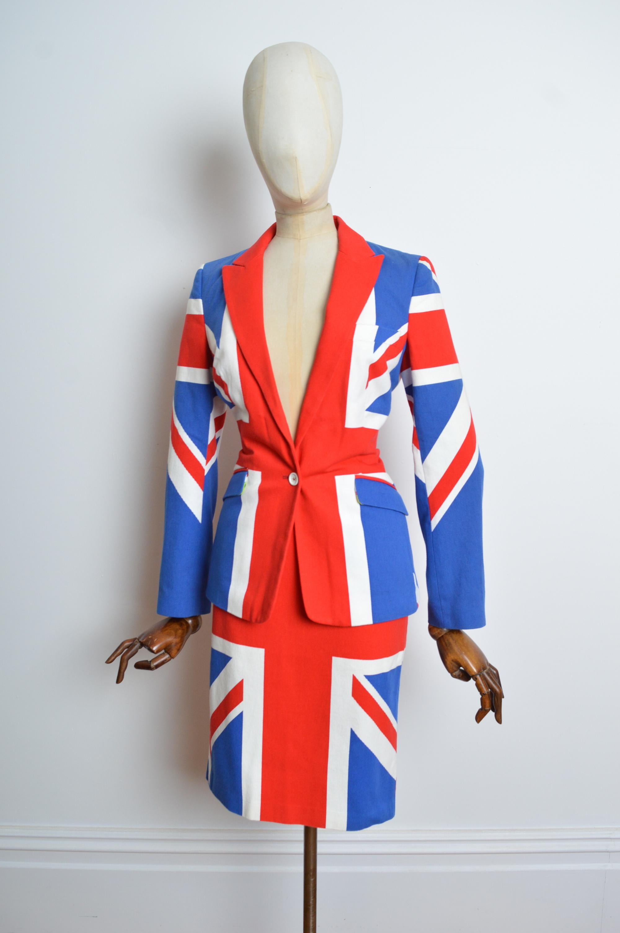 Archival DOLCE & GABBANA Union Jack Blazer Jacket and skirt suit set.
Once in a lifetime find, Archival D&G Cotton Union Jack imprimé Blazer with matching high waisted pencil skirt.  
Recommended Size; U.K. 6 
Measurements are provided in inches