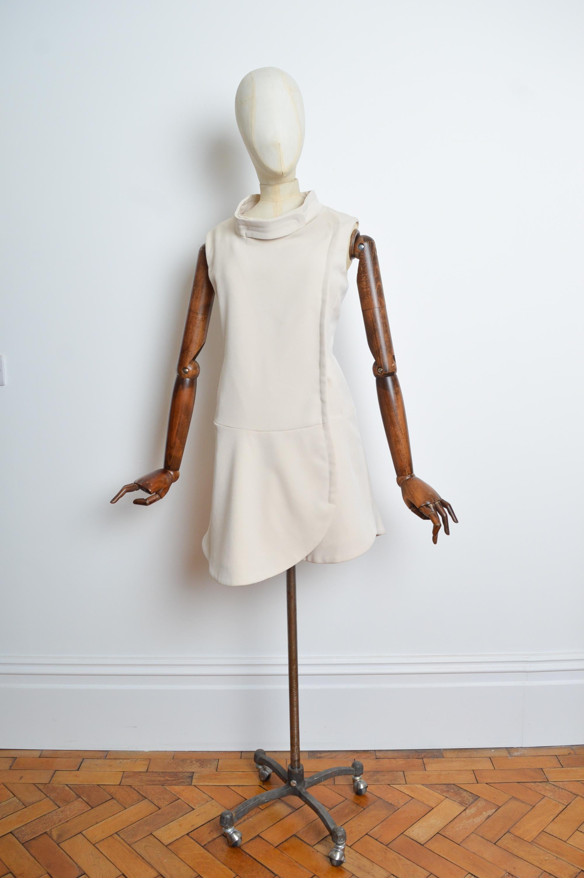 This cream coloured Miu Miu creation comes from the fall 2009 collection, and features a superb 1960s Style 'Pierre Cardin' style cut with off centre press-stud closure, hip pockets, drop waist and above the knee length hem. Designed by Miuccia