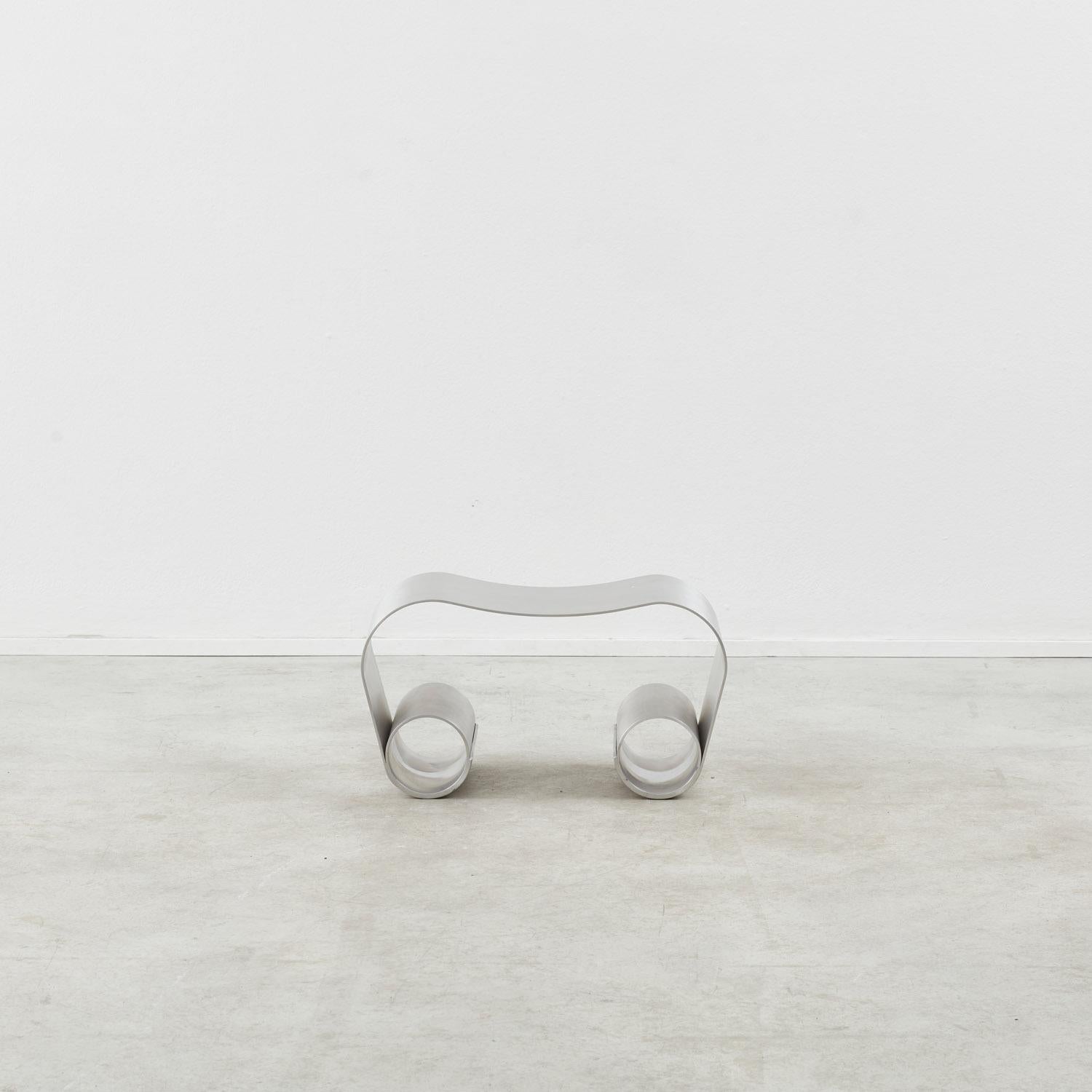 This distinctive stool in aluminium was designed exclusively for Béton Brut by Archive for Space. An exercise in imaginative modern metalwork, it is made from a single sheet of unsealed aluminium, which is gently folded and welded into two tubes to