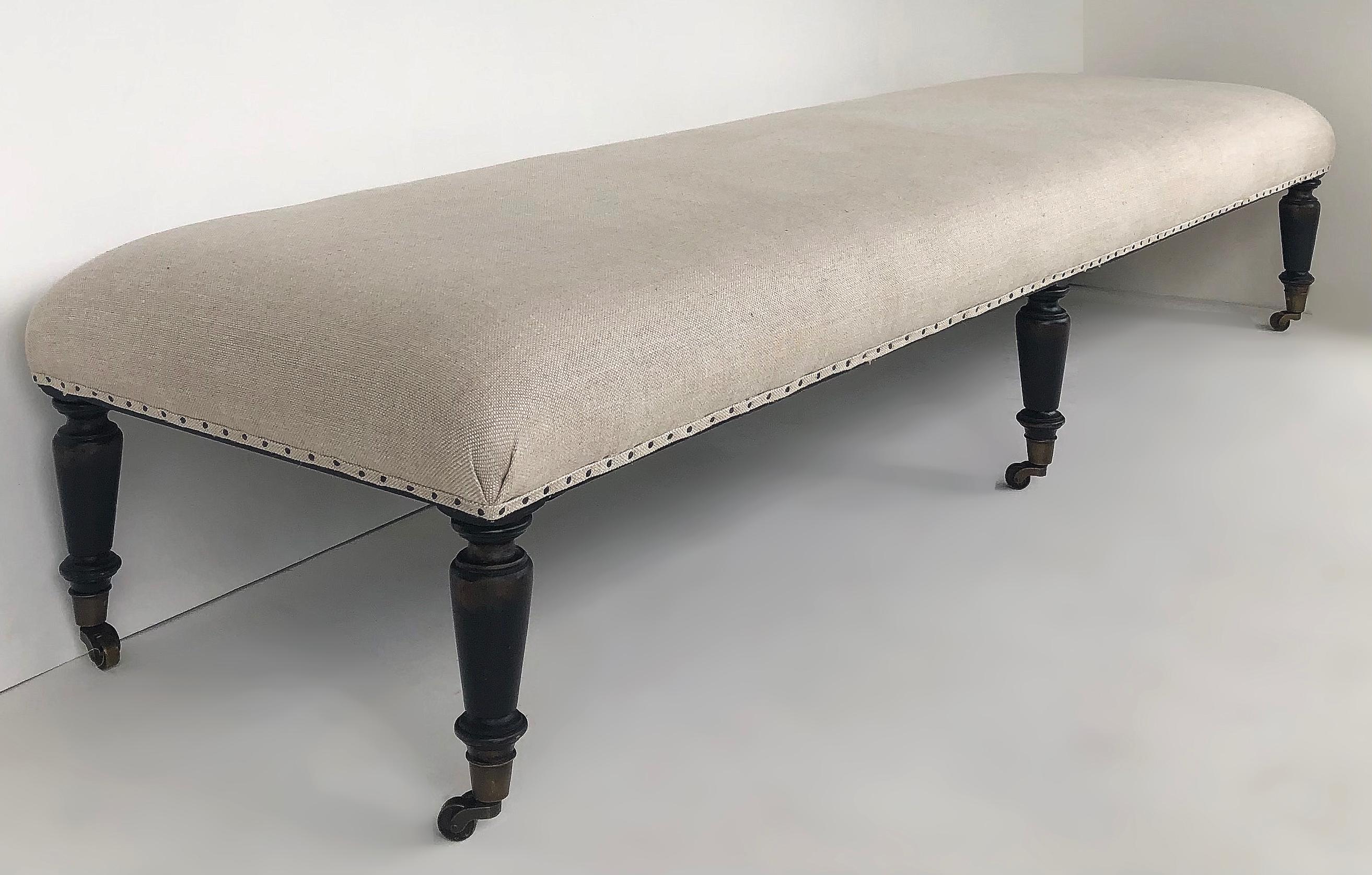 Offered for sale is an Archive Home for Century Furniture Co. long, linen upholstered bench with nail heads and turned, tapering feet on brass casters.