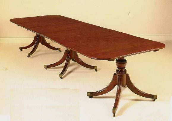 Regency mahogany three pedestal dining table having a rich color and excellent matched graining across the top. The rounded rectangular top raised on ring turned  baluster supports,having two additional leaves (20 1/2