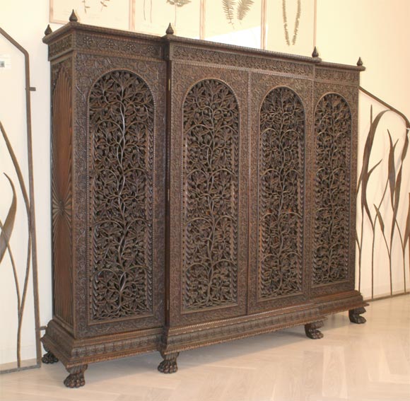 Anglo Indian Elaborate Hand Carved Rosewood Armoire with Arched Paneled Doors, The Breakfront Facade of Swirling Acorn Rose Leaf Design Above A Classic Acanthus Base On Lion Paw Feet and Topped With Flower and Finials, Carved Sunburst Sides on The