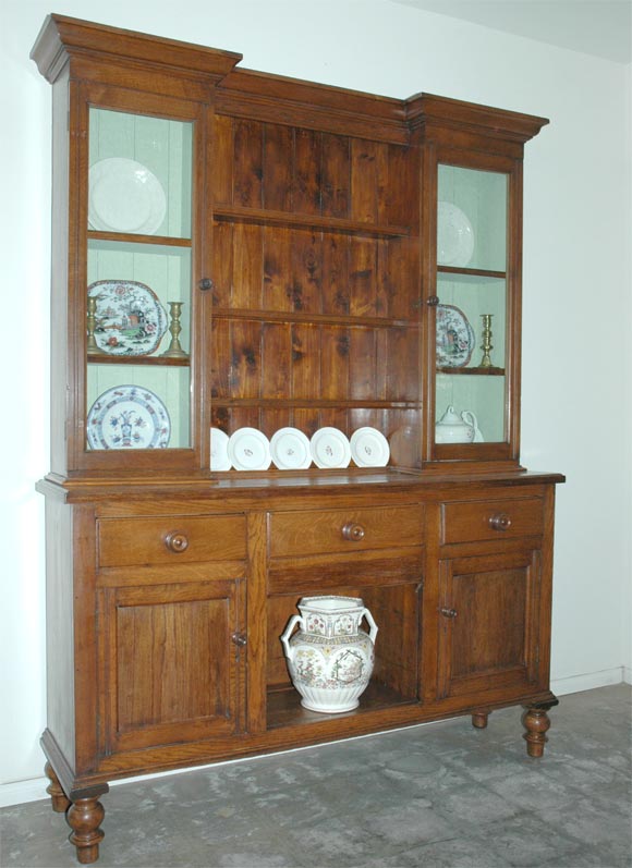 This late 19th century dresser has two tiers, is from Wales and has been professionaly restored to its present pristine condition. The breakfront top tier has shelving and plate stops in the middle, with a cabinet to each side. Each cabinet has a