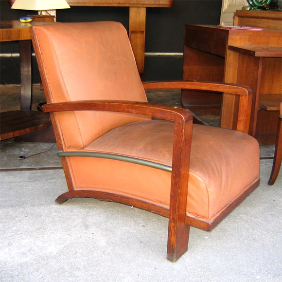 Solid oak armchair with brown fake leather upholstery imitating pigskin. Chromed metal bar below arm-rests.