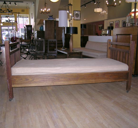 oak daybed by gustav stickley.  original surface, with rope webbed frame and new custom matress. has original casters.