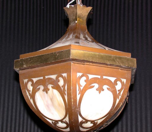 This Arts and Crafts lantern has six open work copper finished brass panels set with slag glass.  The hand worked detailing in each panel is repeated in the top edge as well.