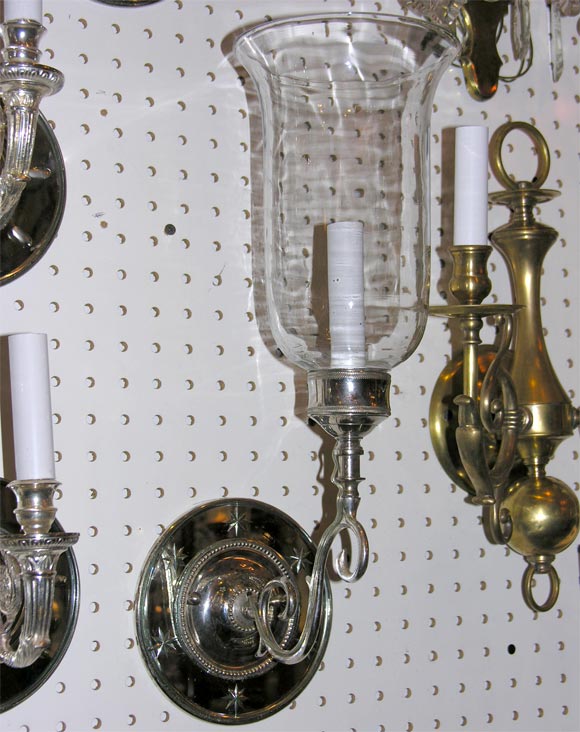 mirrored sconces with starburst etchings and fluted glass shades