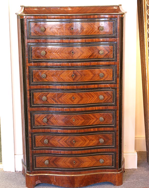 Gentleman's semainier, serpentine shaped front, veneered rosewood ebonized wood trim; beaded brass trim around edge of marble top and individual drawer fronts; floral brass pulls