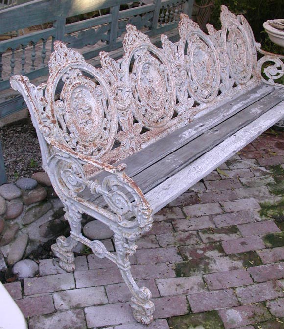 19th Century, heavily patinated cast iron bench with the four seasons depicted on the back.  Beautiful scrolled arms, and  a wonderful lily of the valley motif throught the seat back. Teak seat appears very old, and may be original.