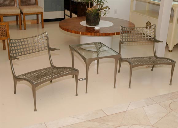 Pair of Dan Johnson cast aluminum chairs with side table. From 
