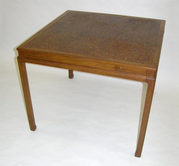 A square game table with a top comprised of nine square cork tiles set in a walnut frame and pivoting cork lined drink holders with brass ring pulls at each corner by Edward J Wormley for Dunbar Furniture Company. U.S.A., circa 1950. [DUF0190]