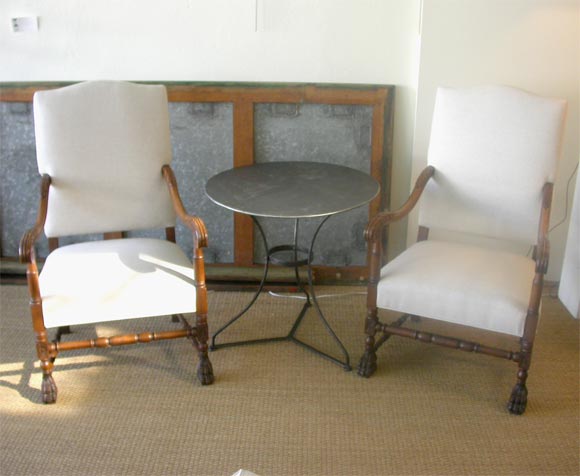 Pair of arm chairs in the style of Louis XIII.  Walnut frames with very fine carving, not hairy paw feet.  Newly upholstered in natural linen.