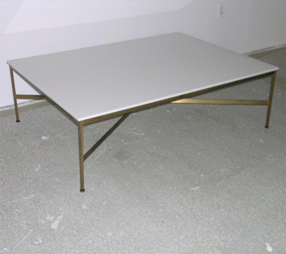 A brilliantly executed cocktail table with white Carrara Vitrolite glass supported by a square brass frame, mod. no. 8703, by Paul McCobb for Calvin. American, circa 1950. Please call for availability.