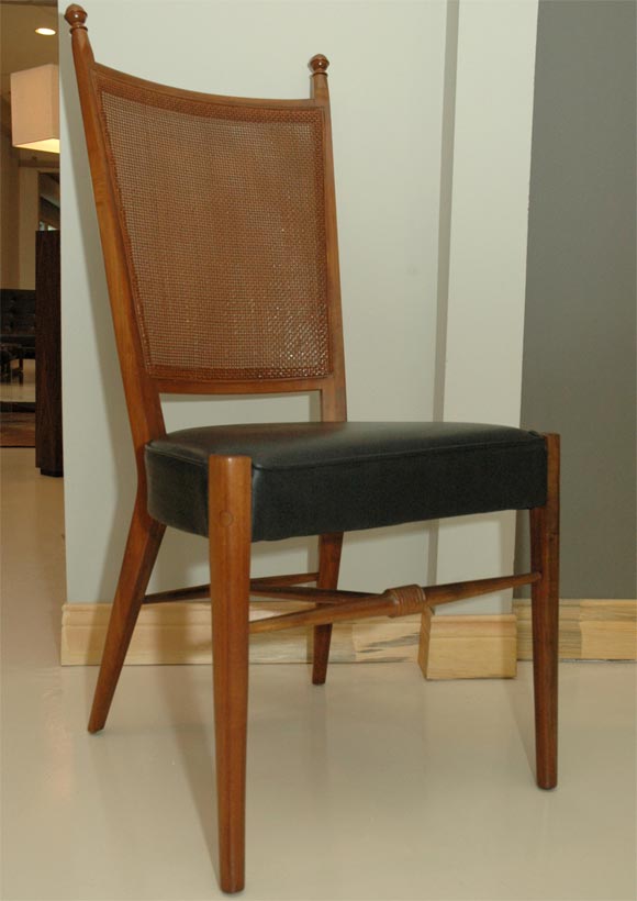 Set of four graceful mid-century caned back dining chairs attritubed to Edward Wormley for Drexel.  Back legs gently angle back and are held together by a turned   H-base.  Back posts of chair terminate at paired down cup-and-cover  finials. 