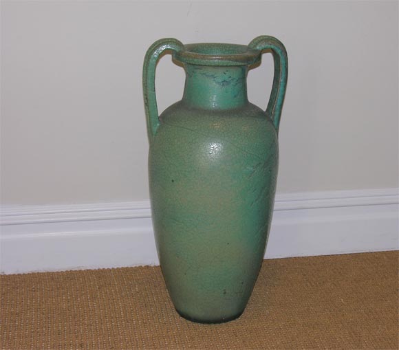 The slopping shouldered tapering cylindrical body, applied with ribbed loop handles from the mouth to the shoulder, covered in a streaked crackle turquoise glaze.