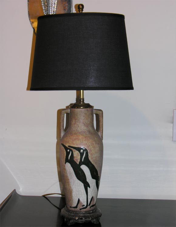 Ceramic lamp depicts a pair of penguins on the<br />
front side and a single on the back.  The <br />
lamp rests on a bronze base and is signed.