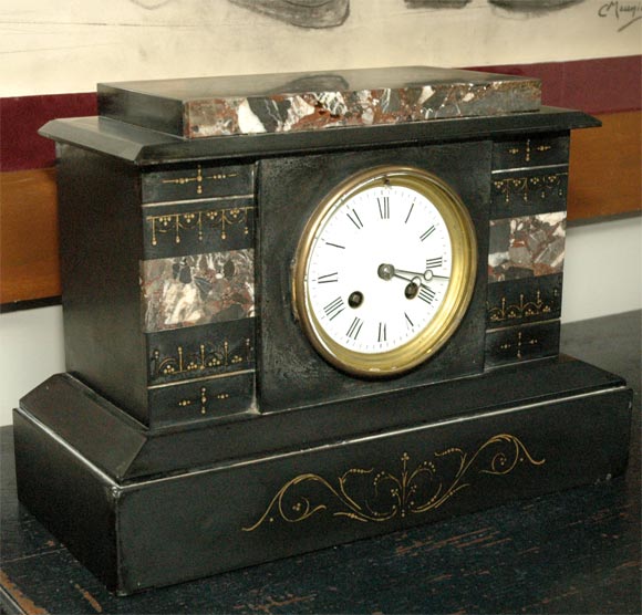 Large green and black marble table clock from 1880s France. With delicate gilt detailing, white enamel clock face, and elegant Roman numeral lettering, the piece is a beautiful example of a domestic timepiece in the neoclassical style. A handsome
