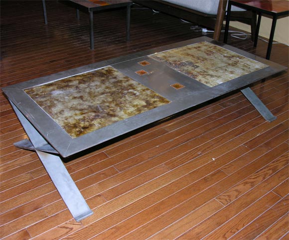 Coffee table with glazed ceramic top and framed in stainless steel.