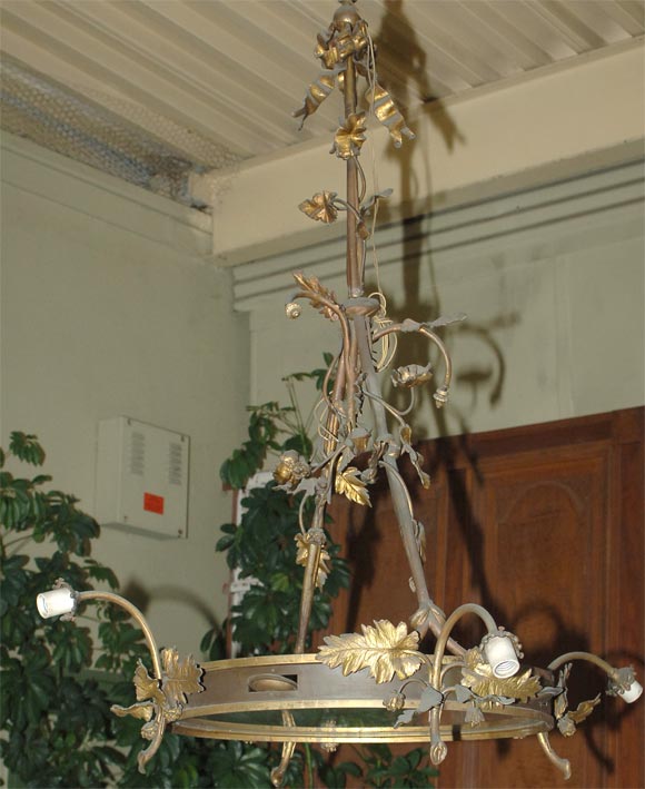 BEAUTIFUL WORKMANSHIP DISTINGUISHES THIS TAMBOURINE SHAPED WROUGHT IRON AND GILDED CHANDELIER.GILT OAK LEAVES, BUDS AND RIBBON WITH SMALL TAMBOURINES INCORPORATED IN THE FRAME.4 EXTERIOR LIGHTS AND 4 INTERIOR LIGHTS WITH ETCHED GLASS BASE.