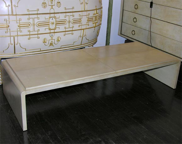 Parchment covered waterfall style low table, French circa 1980<br />
57” w, 23” d, 12