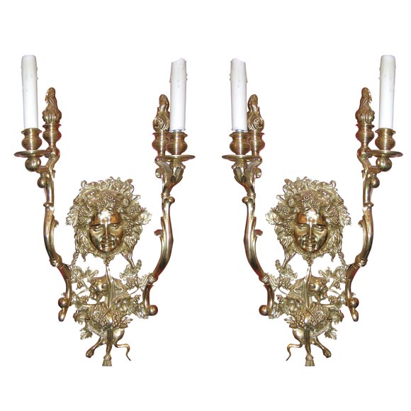PAIR OF BRONZE SCONCES WITH FACES ON EACH THAT ARE DIFFERENT