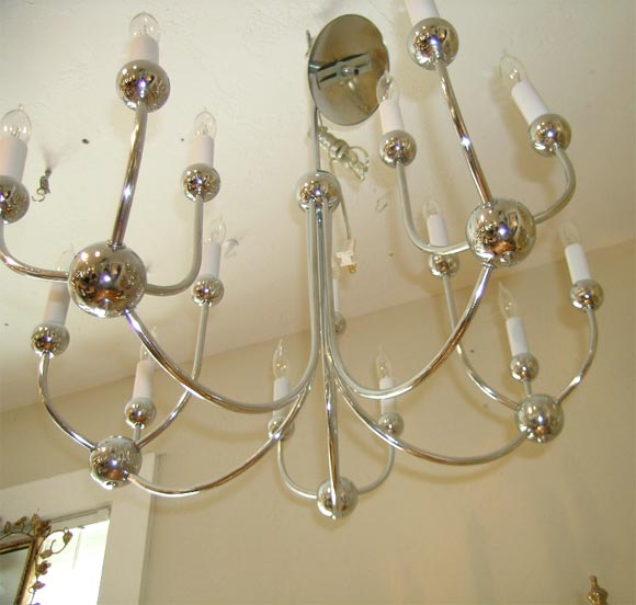 Chrome chandelier in a molecular design featuring 5 arms holding 3 candles each