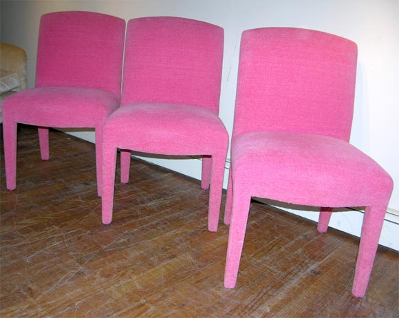 Six beautifully upholstered dining chairs in a vibrant hot pink basket weave chenille fabric by donghia.