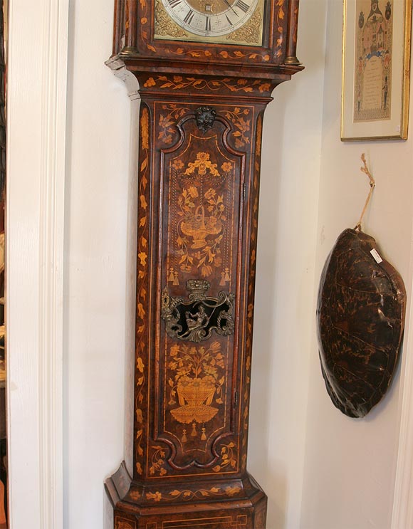 18th century Dutch marquetry tall case clock with english works. The marquetry is exceptional. Has original atlas figure on top and what appears to be the original works and parts.