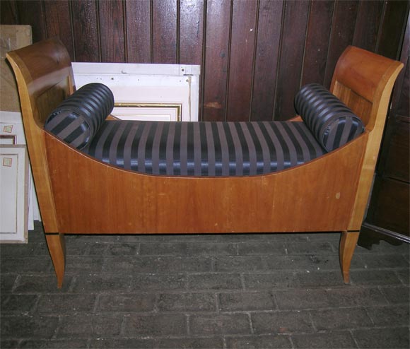 Inset cushion with two neckroll pillows wooden bench.