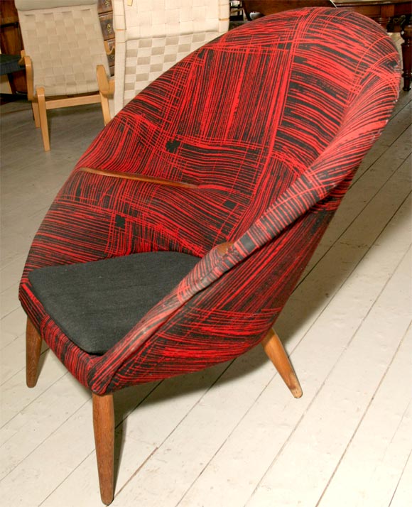 Curved easy chair designed by Danish modern designer Nanna Ditzel in the 1950's in its original wool fabric, with teak legs and embedded arms.