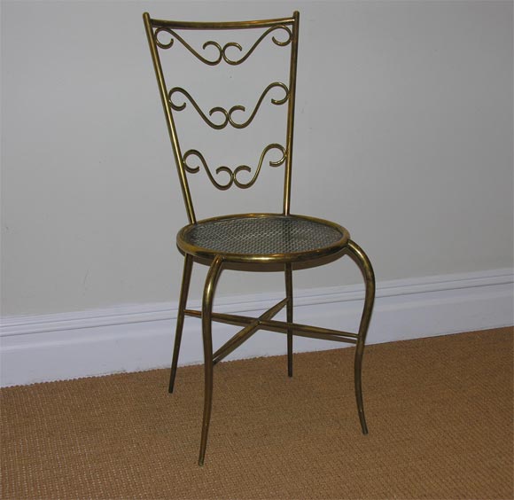 Each a circular seat supported on tapering brass legs, with a cross stretcher, the backs with scrolling details.